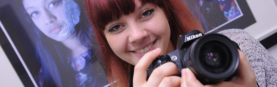 girl with a camera smiling